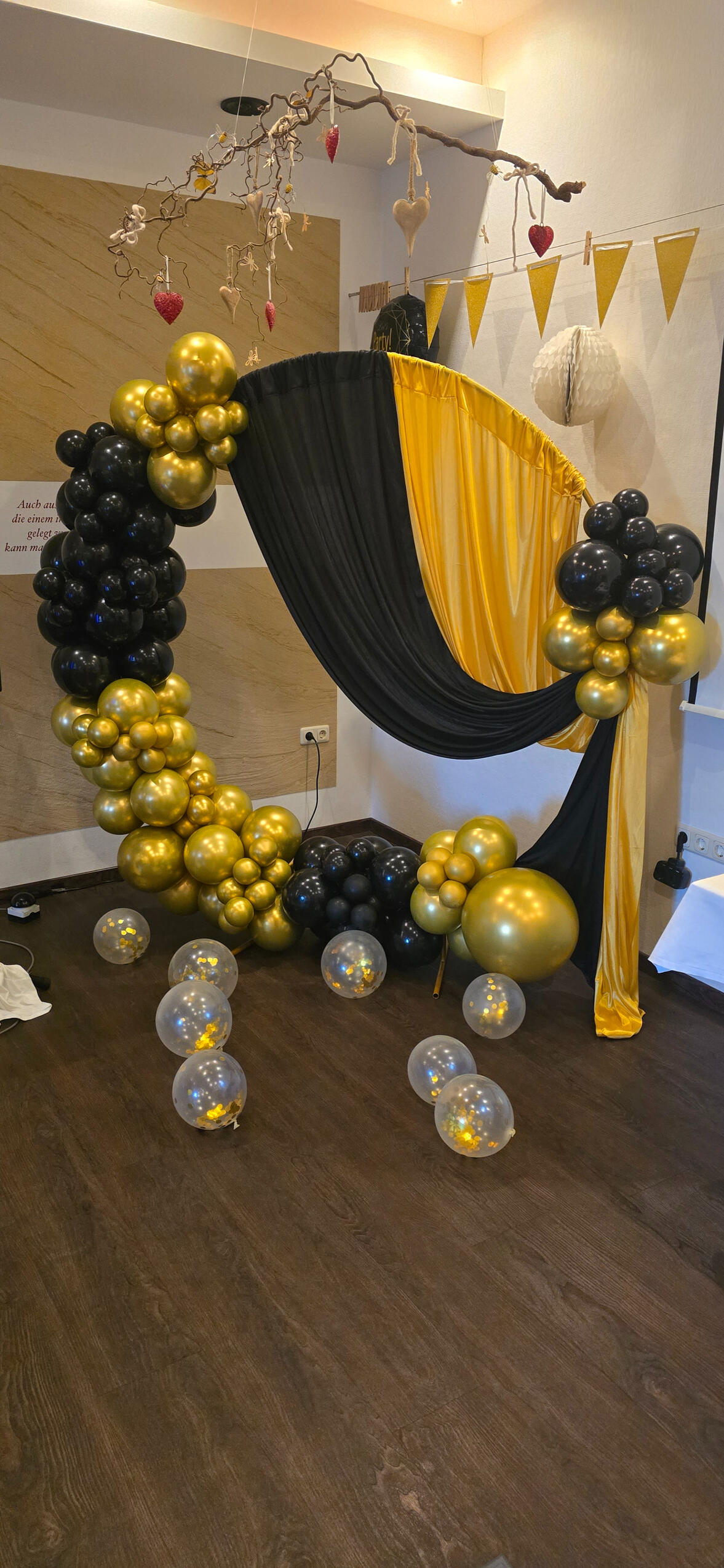 Ballonbogen in Schwarz und Gold mit Stoffdrapierung